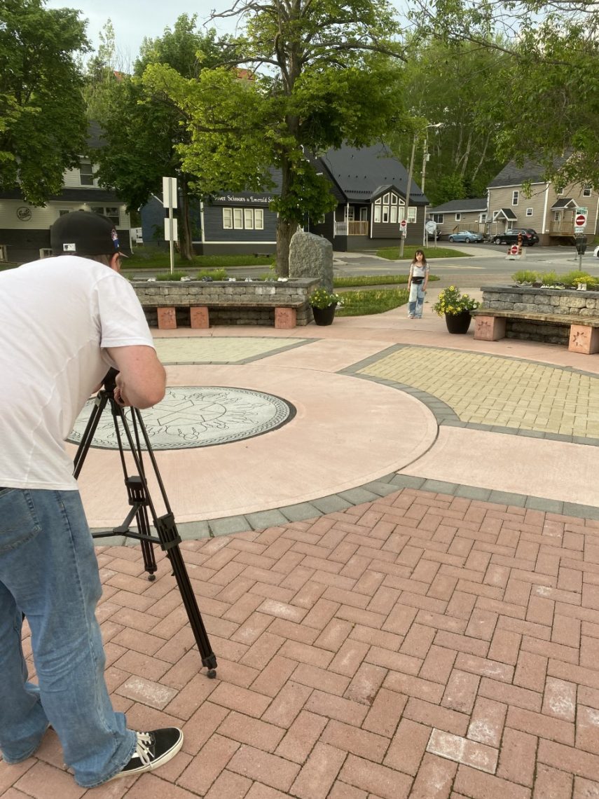 A person with a camera films in a residential neighbourhood