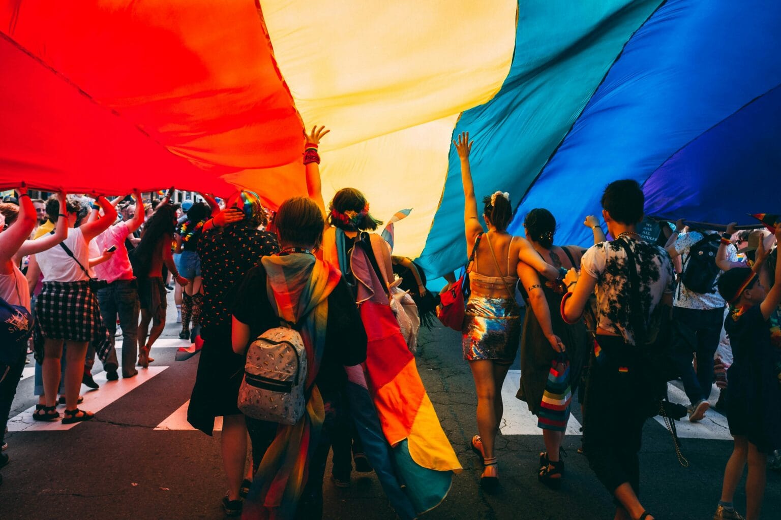 Group of youth under a pride flag